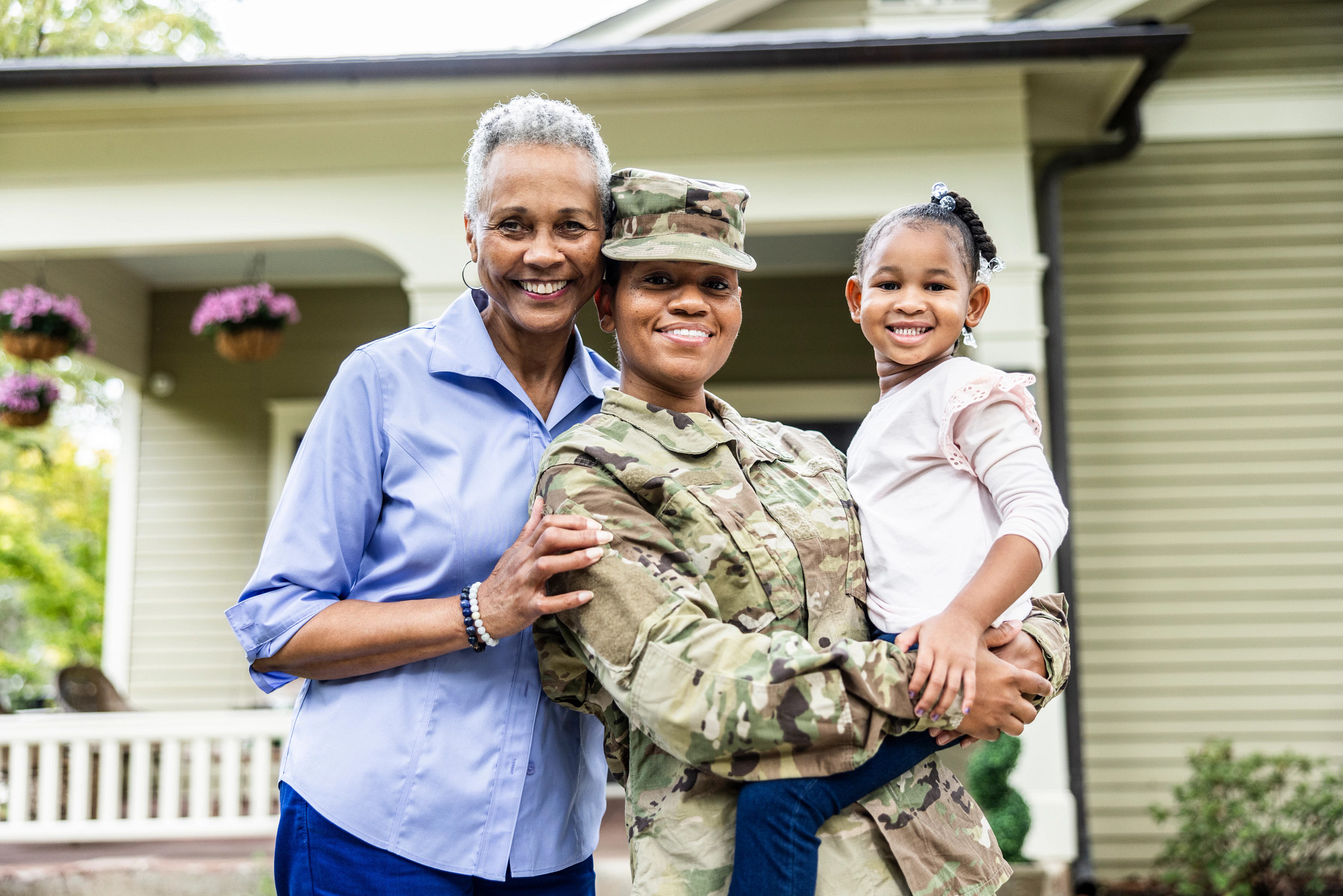 Portrait of female U.S. soldier and senior mother in front of home