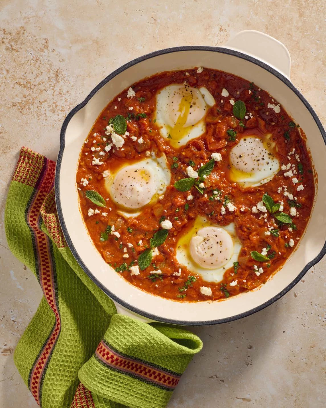 Poached eggs in a tomato and red peppers sauce with spices in bowl