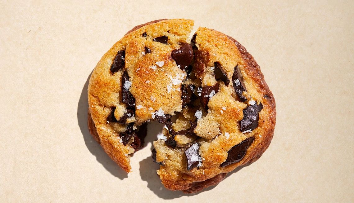 Chocolate Chip Cookie Day Deals An overhead photo shows a gooey chocolate chip cookie sprinkled with salt