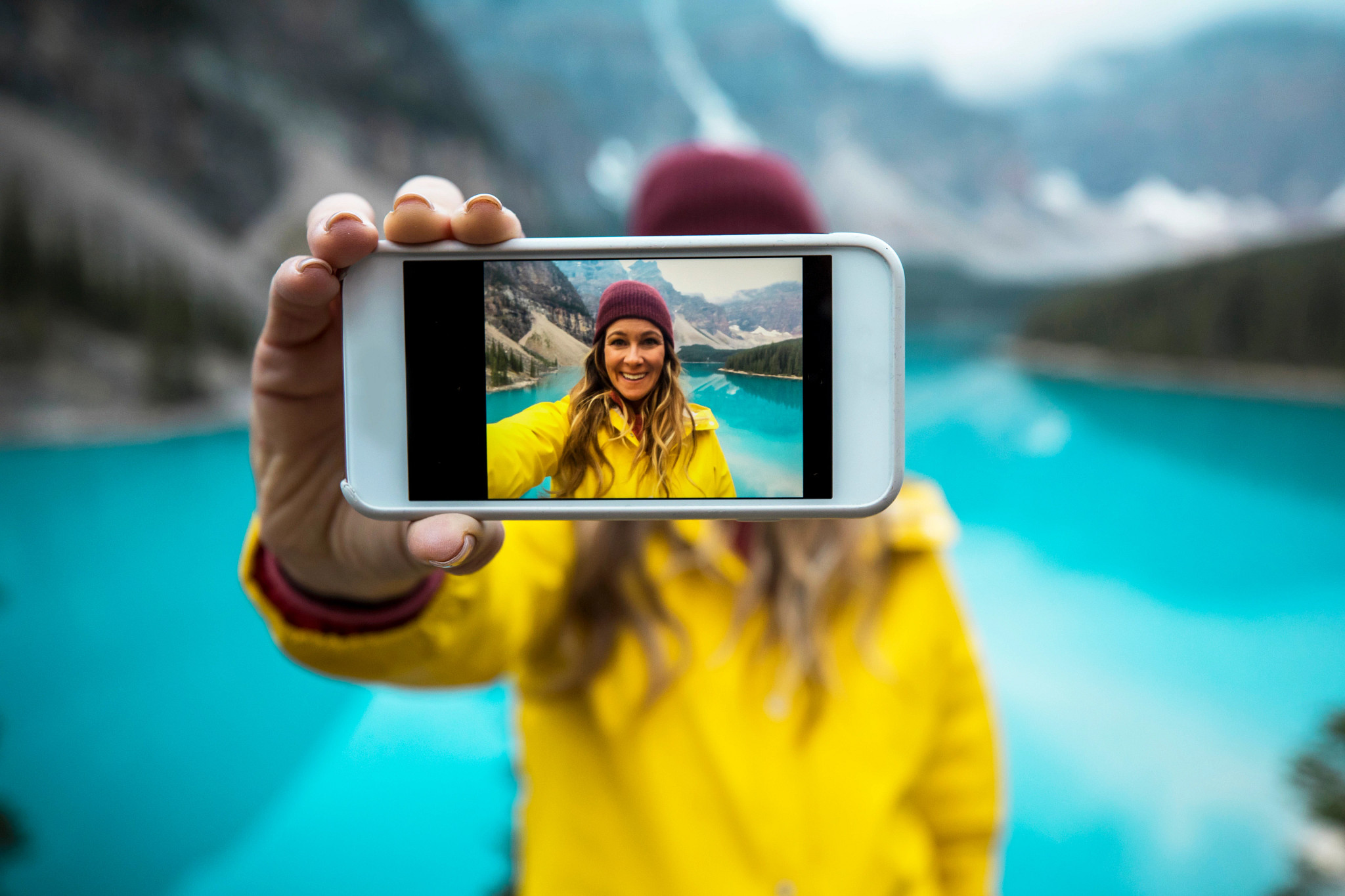 woman taking a selfie next to a glacial lake