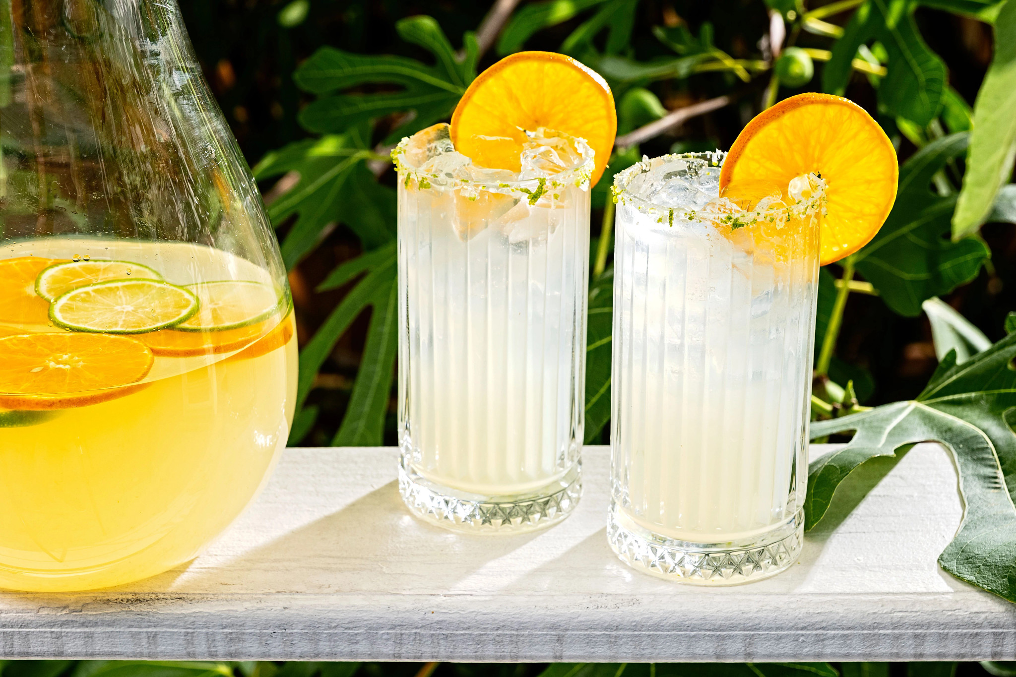 a pitcher and two glasses of Classic Daiquiri on a table