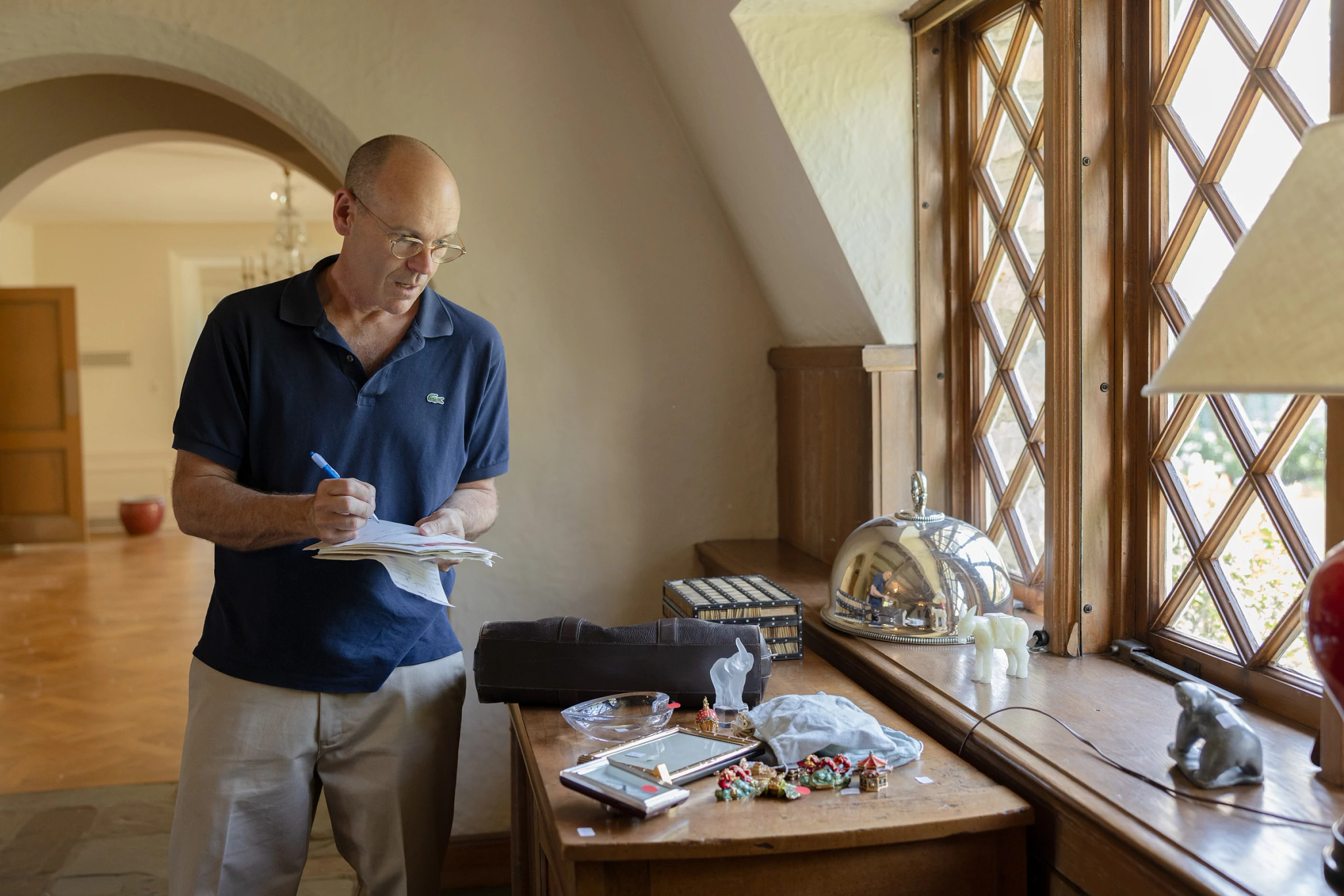 estate sale hosting tips chris coy takes notes about items on a desk
