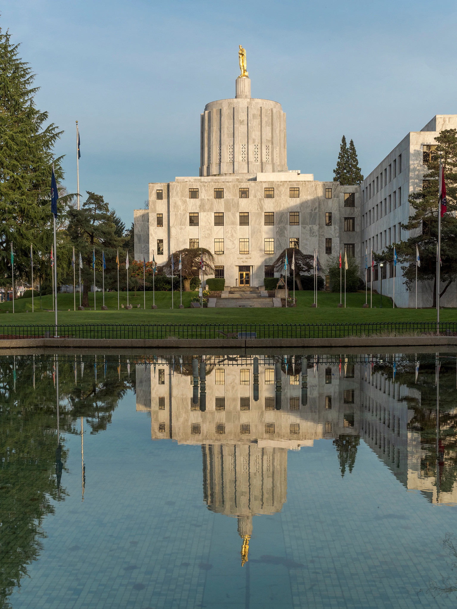 A side view of the Oregon State Capitol building from across a water feature with capitol reflection. Located at the State Capital Salem, Oregon.