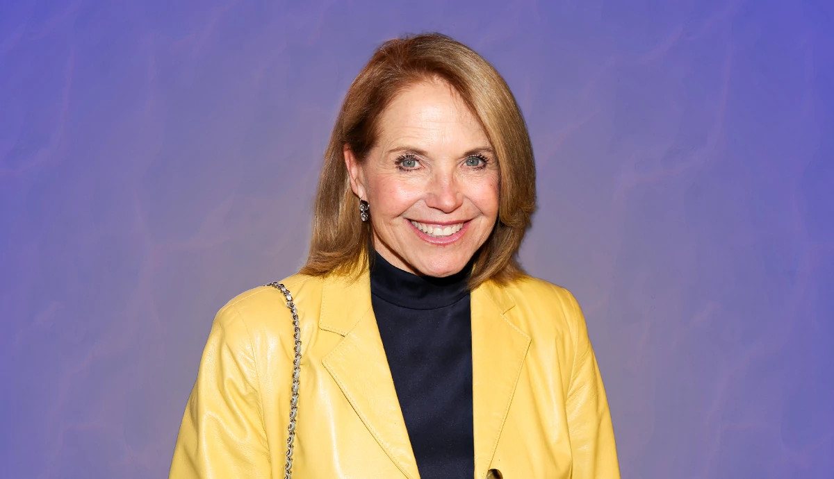 katie couric smiling, wearing a yellow leather jacket