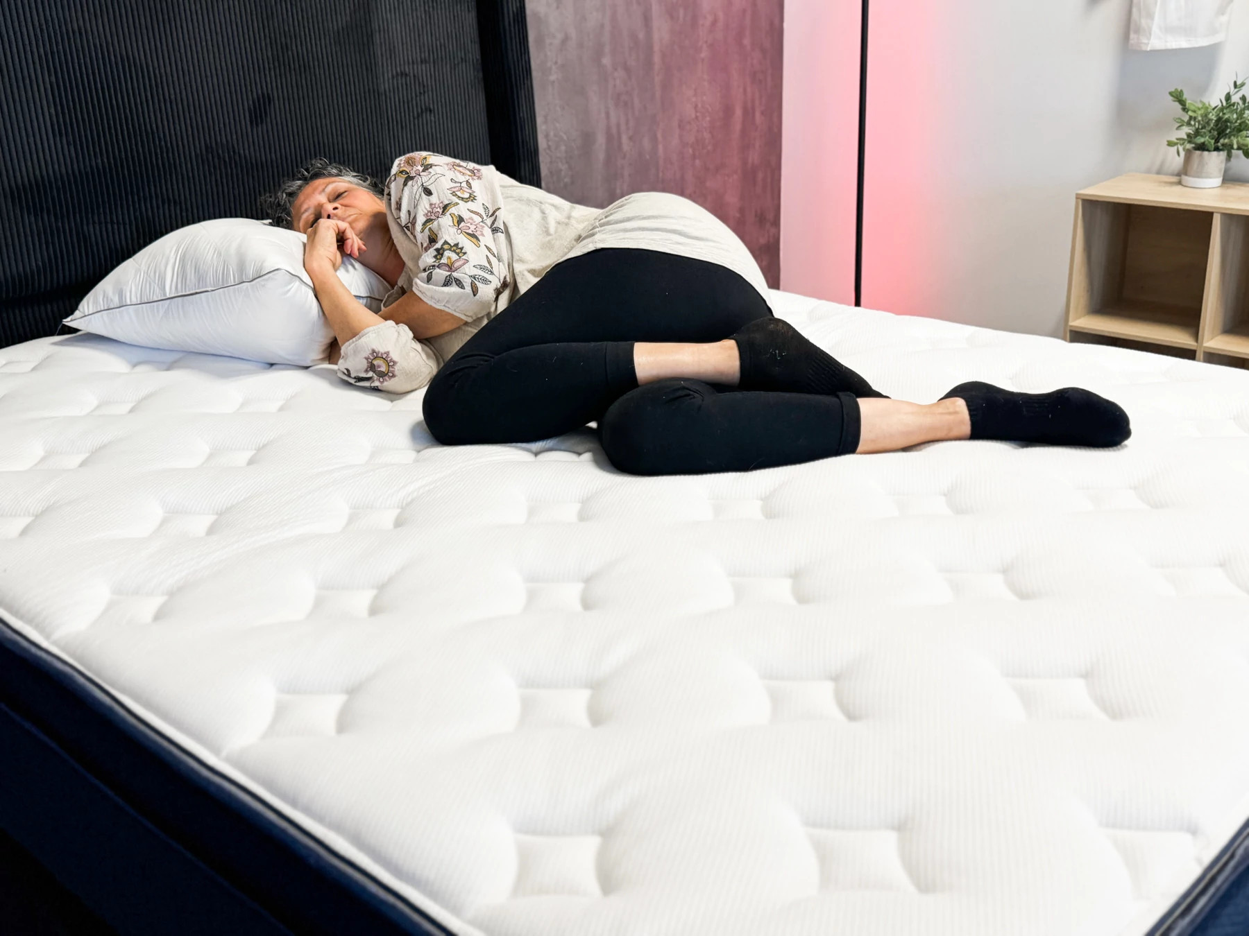 Woman lies on her side on a mattress