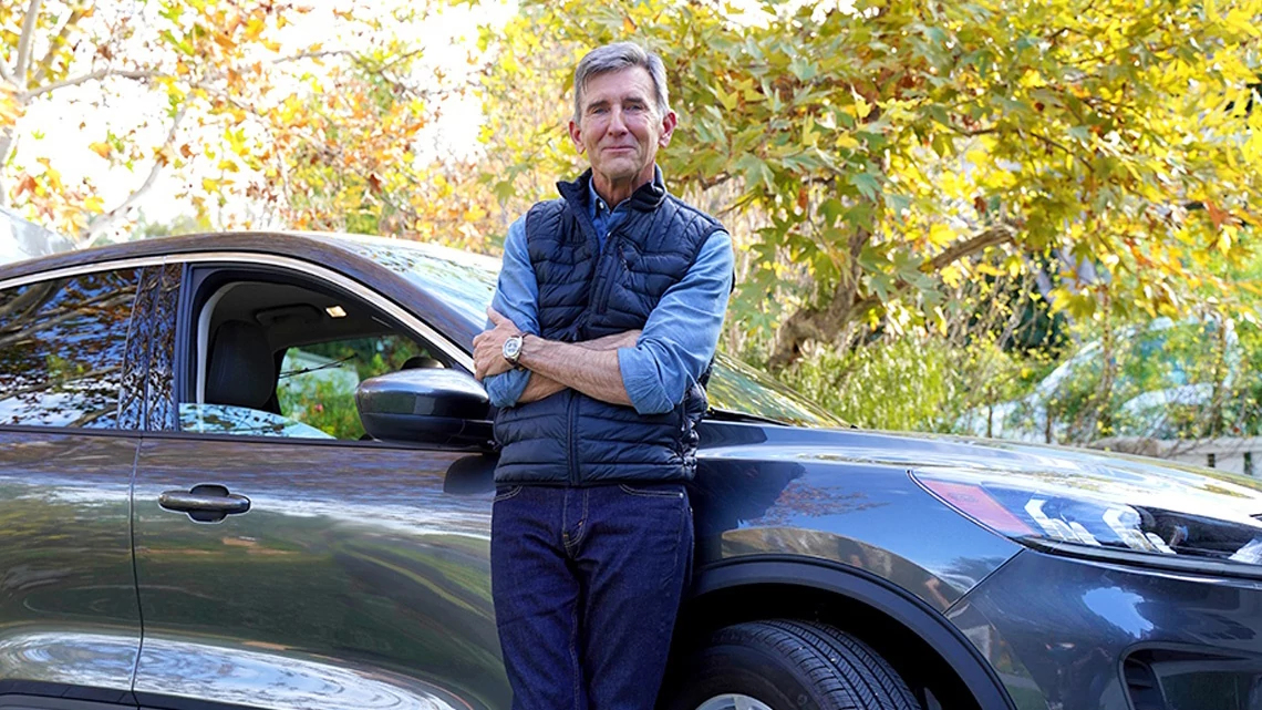 Man leaning against blue car