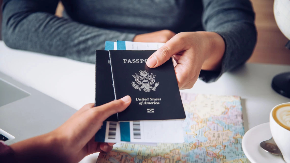 RushMyPassport Two US passport being handed over from one person to another can only see hands