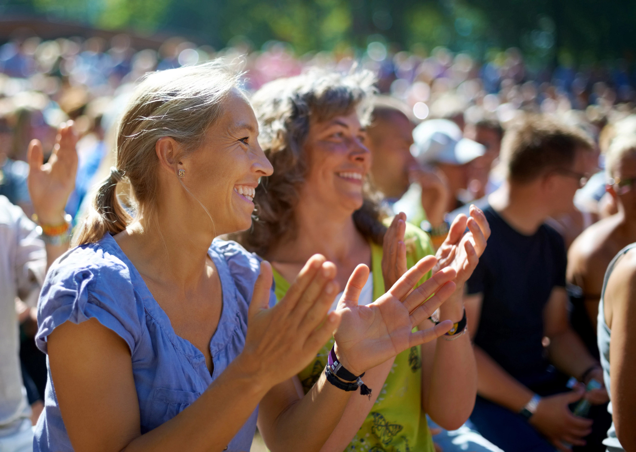 Two mature woman sitting outdoors at a music festival