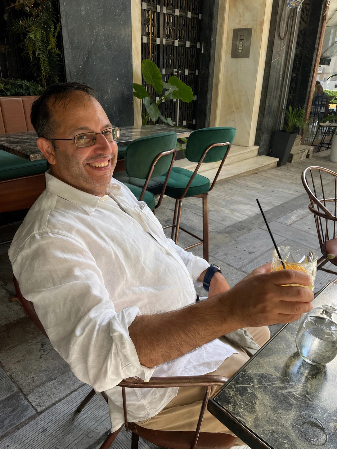 andrew gulli smiling, wearing a white shirt and glasses