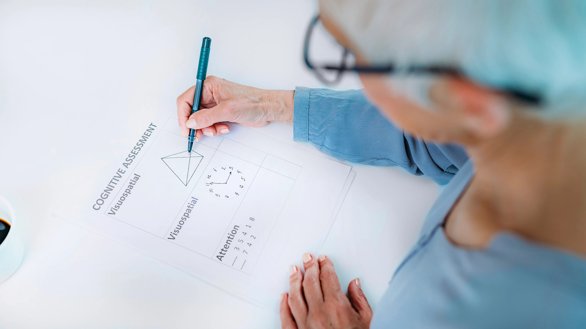 A woman with a pen in her hand taking a cognitive assessment on paper.