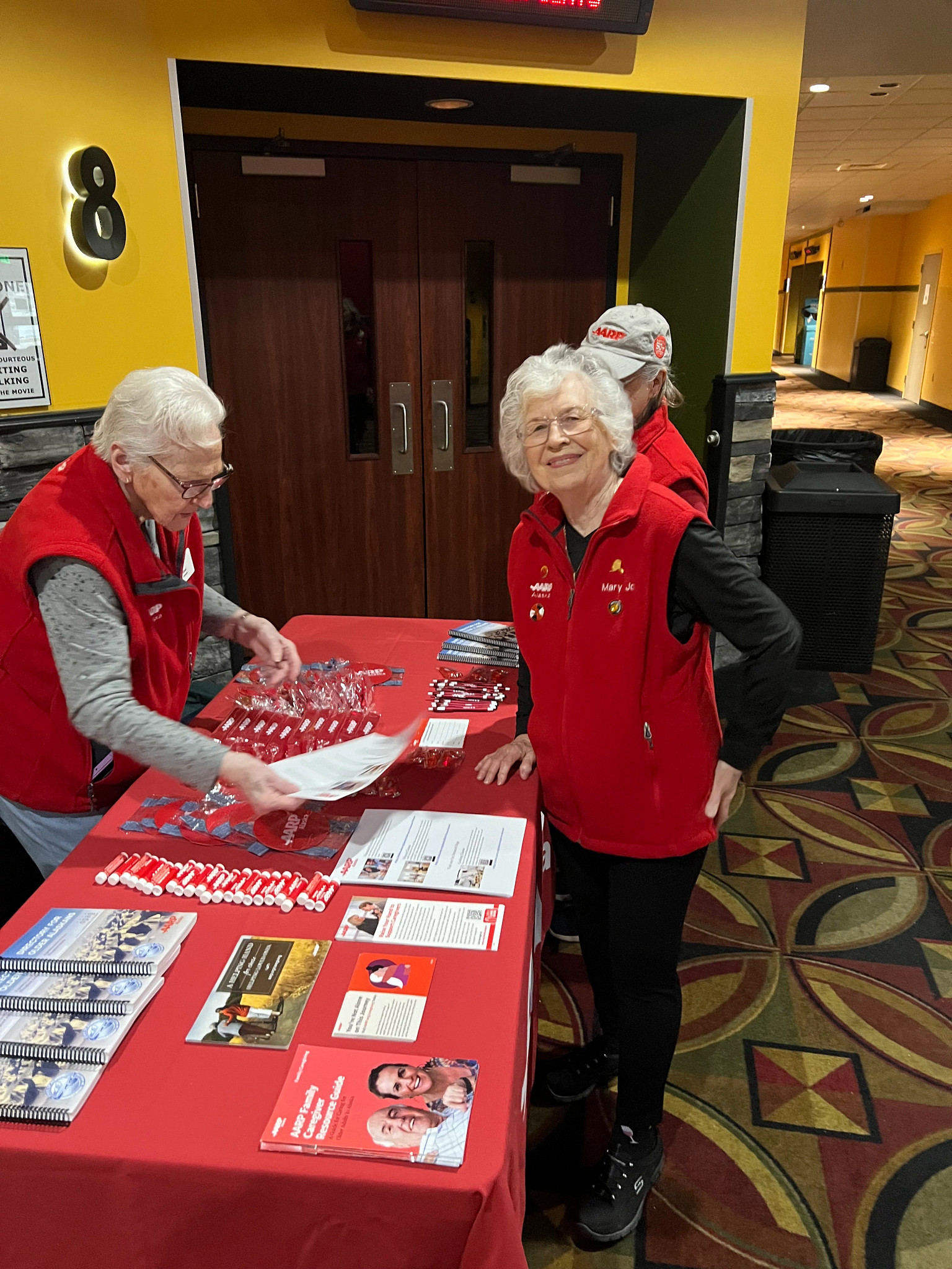 Volunteers Ethel, Mary Jo and Linda prep for Movies for Grownups
