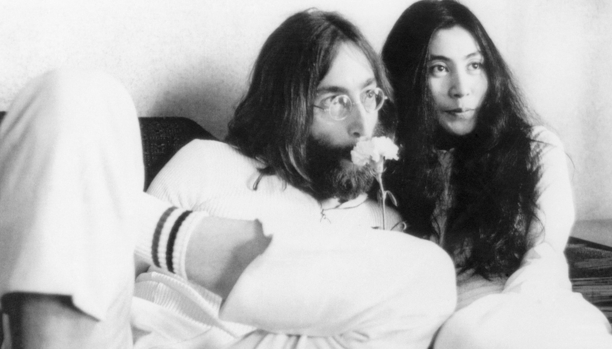 John Lennon sniffs a flower in bed with wife Yoko Ono