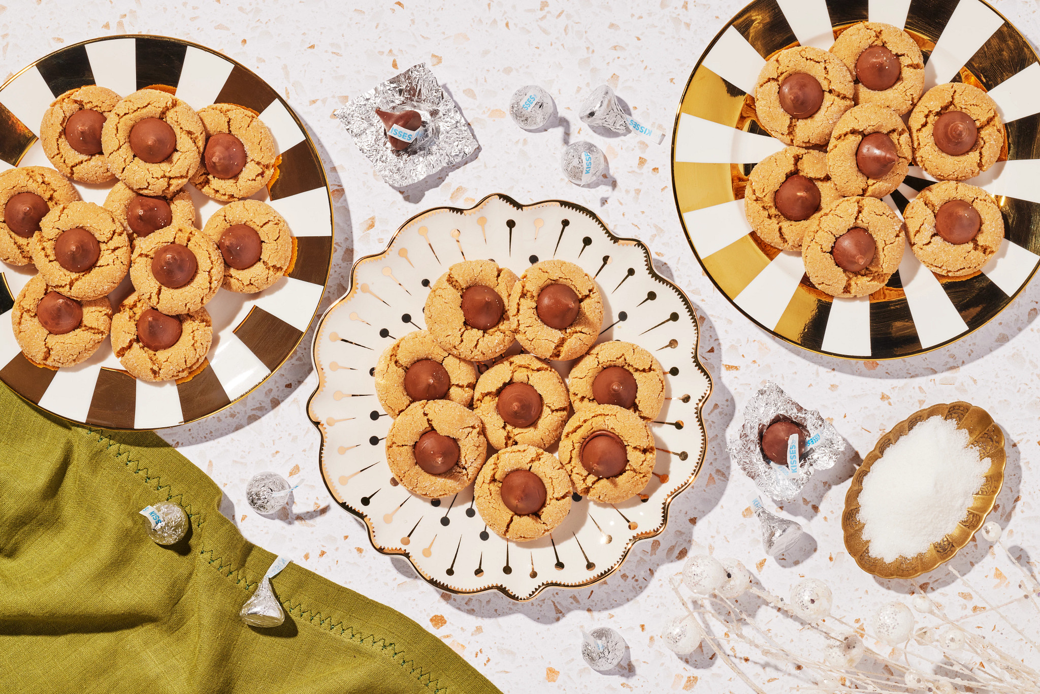 Homemade Christmas cookies with chocolate centers arranged on festive striped plates and serving dishes