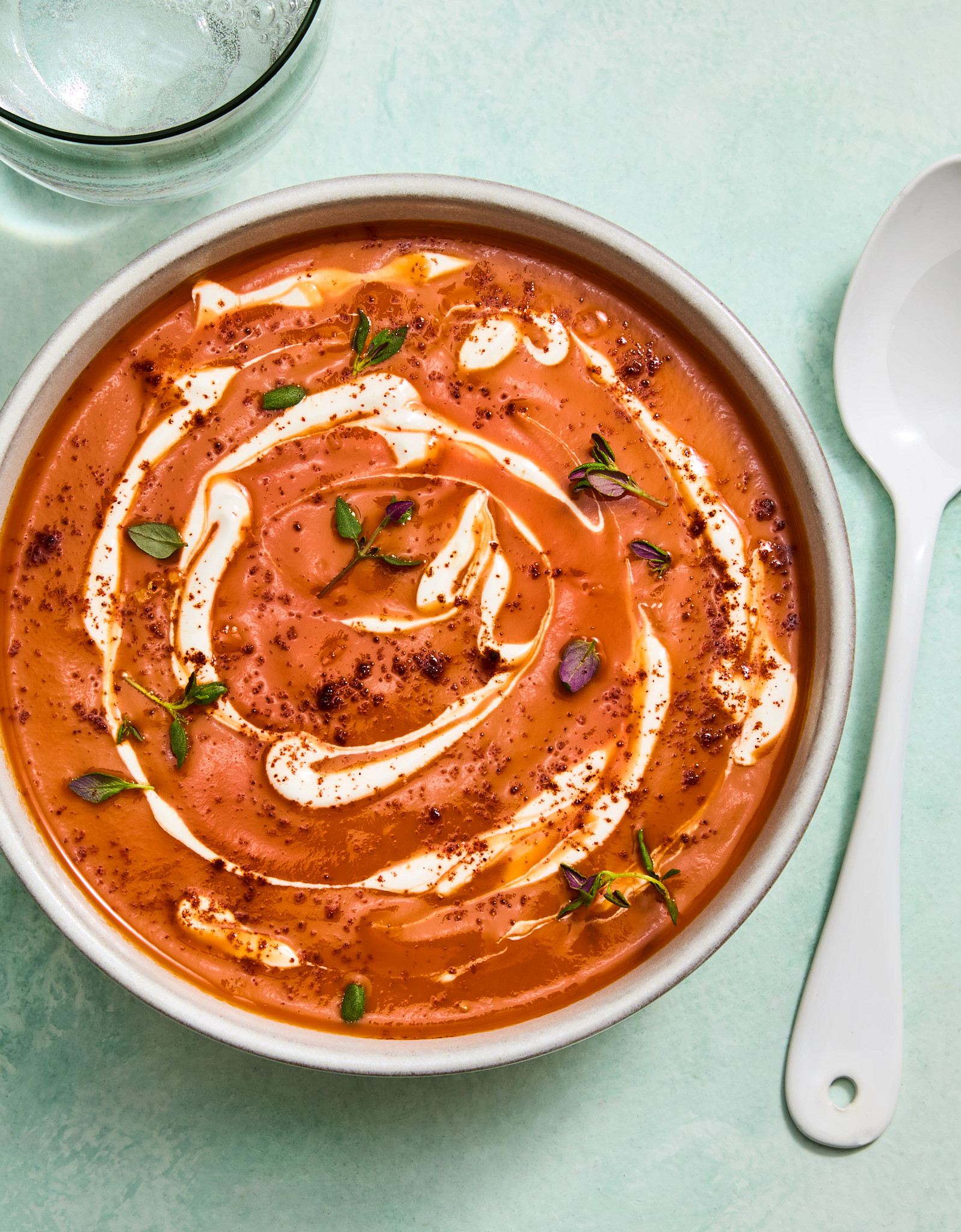 roasted carrot and tomato bisque with crème fraîche is shown in a photo