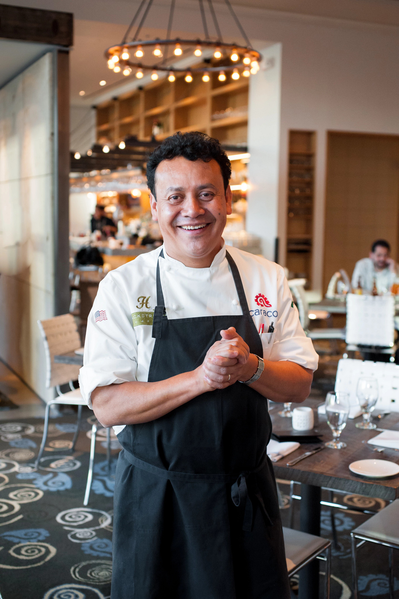 Chef Hugo Ortega posing inside his restaurant