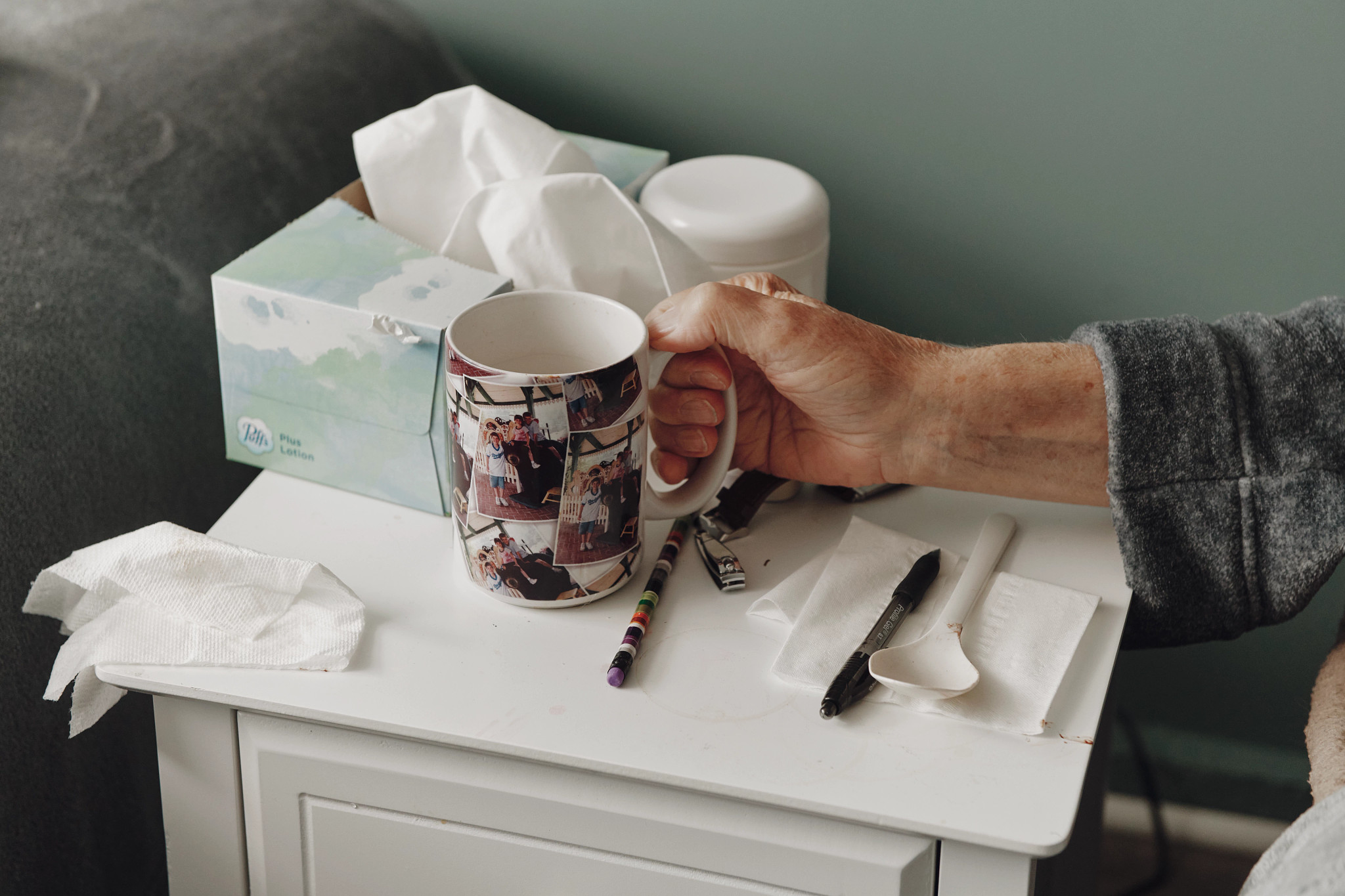 a hand holds a mug covered in family photos