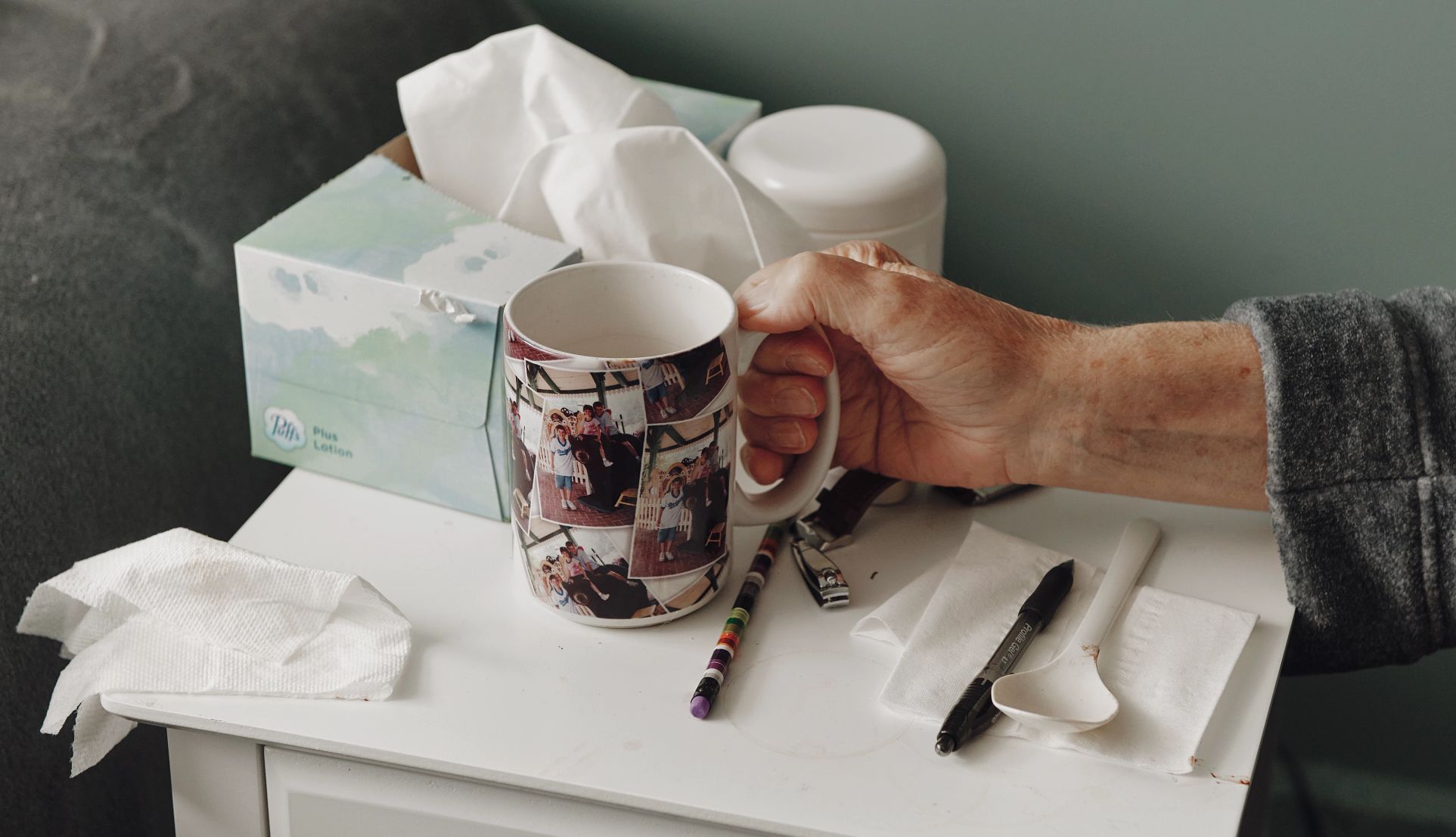 a hand holds a mug covered in family photos