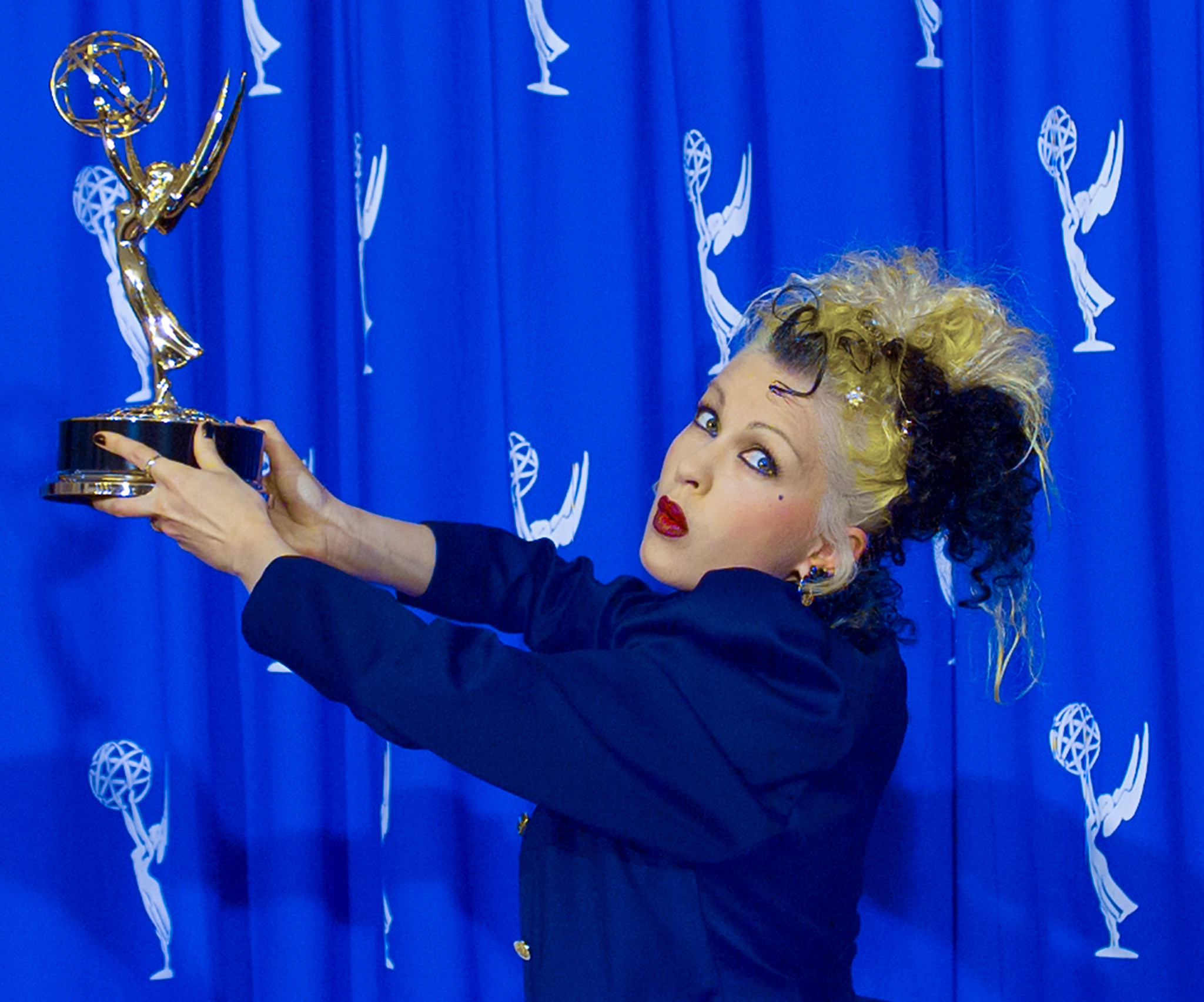 cyndi lauper posing with her emmy award