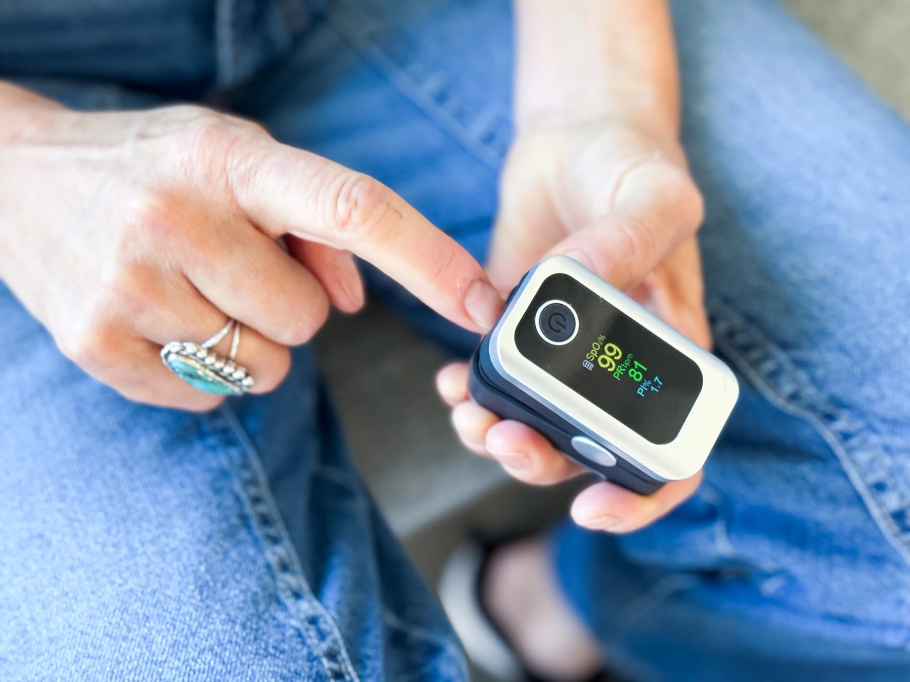 Woman places her finger into a pulse oximeter