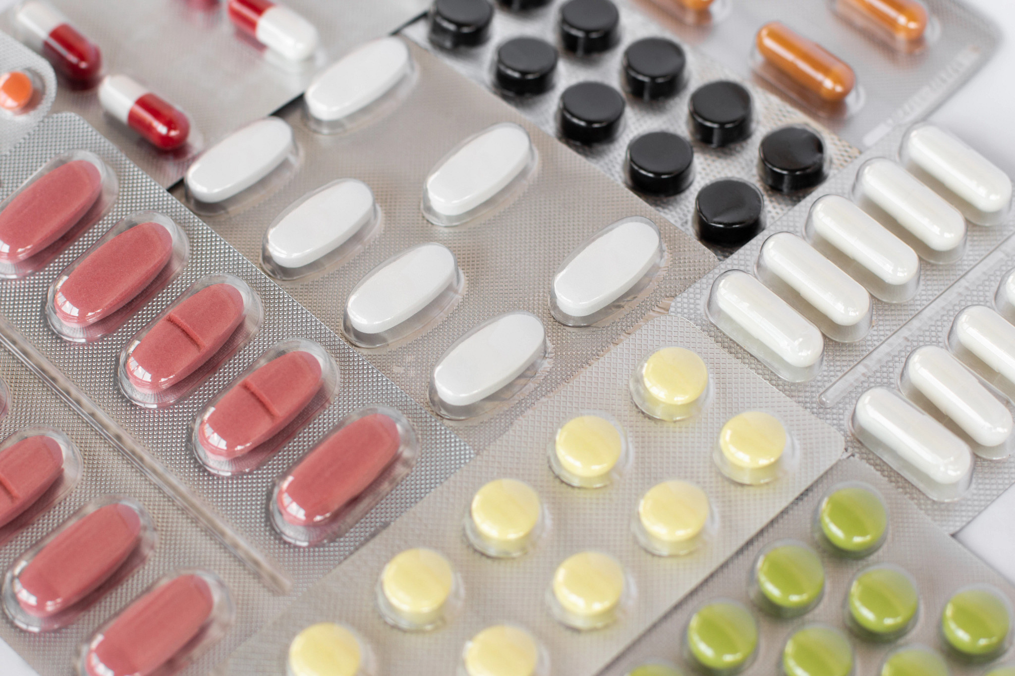 A close-up, high-angle view of various medication blister packs arranged closely together.