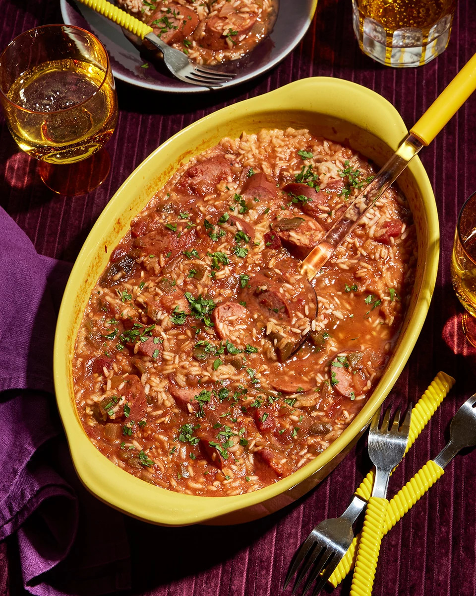 Sausage and rice casserole served in a yellow baking dish with a serving spoon