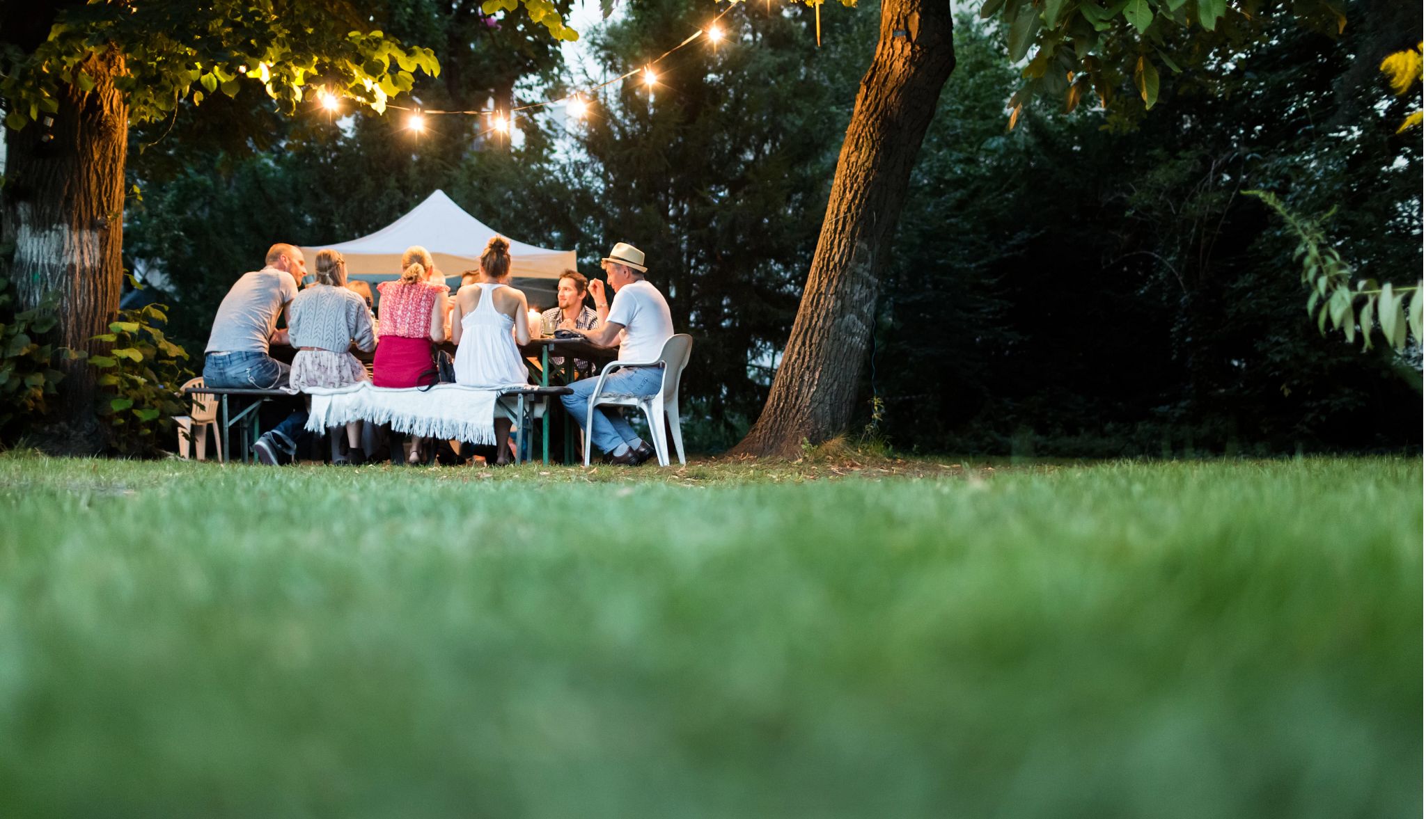 Happy family sitting together and dining in the garden Happy family sitting together and dining in the garden