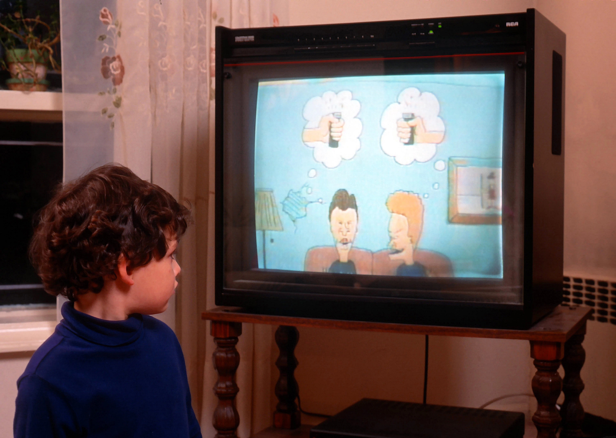 a child staring at a television that is displaying an image from an episode of beavis and butthead