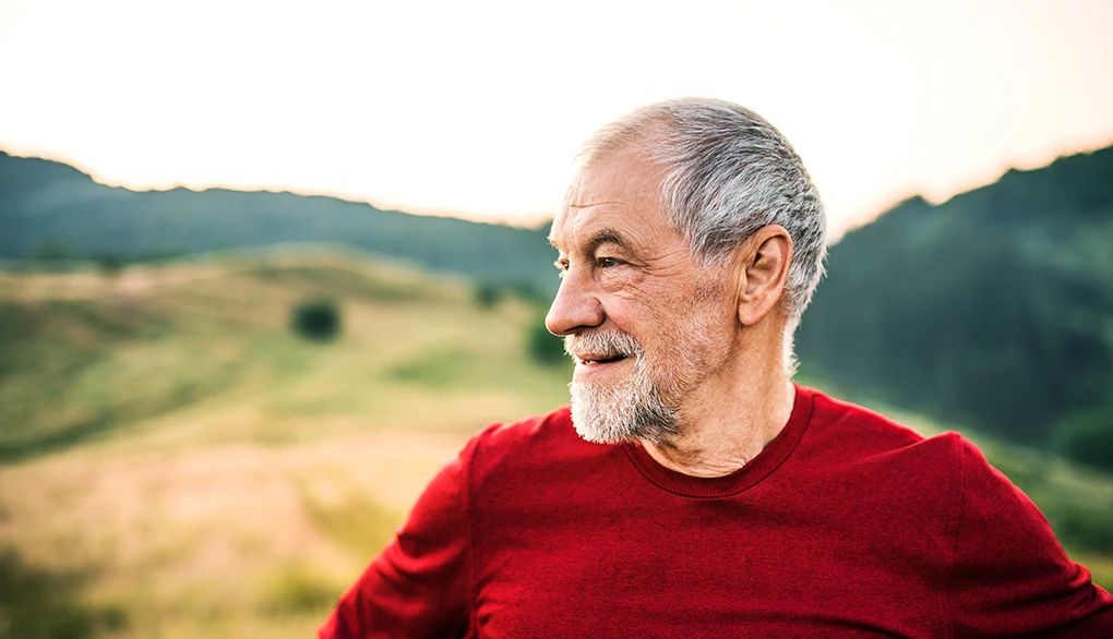 The pursuit of happiness can hinder certain aspects of well-being A man looking in the distance outside in nature