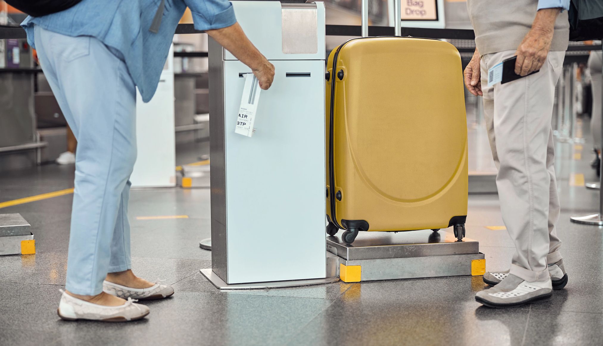checked baggage quiz couple printing luggage tags at an airport