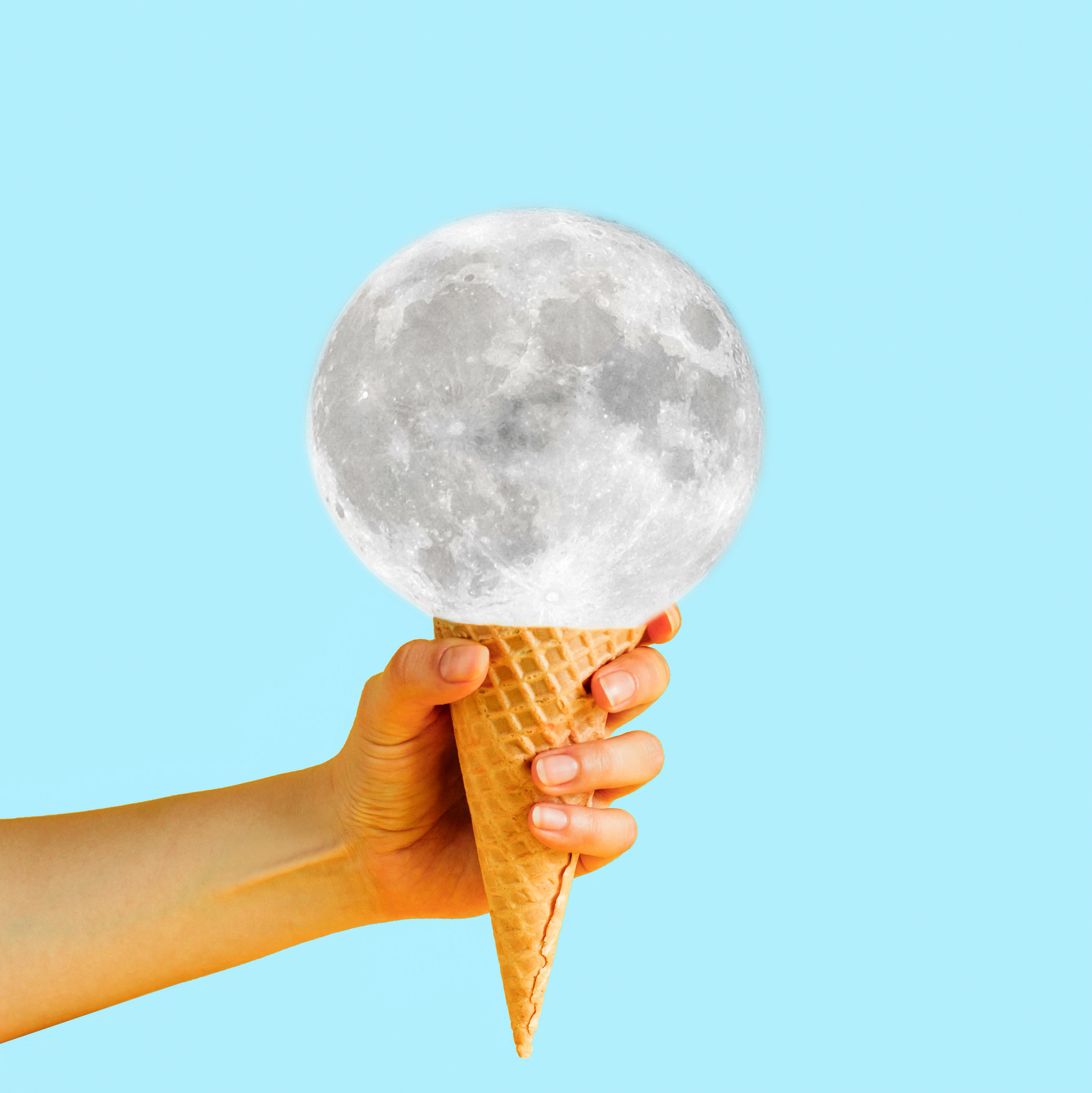 a hand is holding a cone with the moon on it