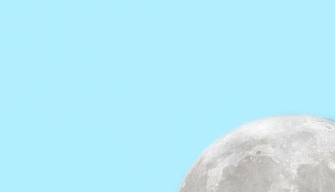 Solar Eclipse Food Deals and Promotions a hand is holding a cone with the moon on it