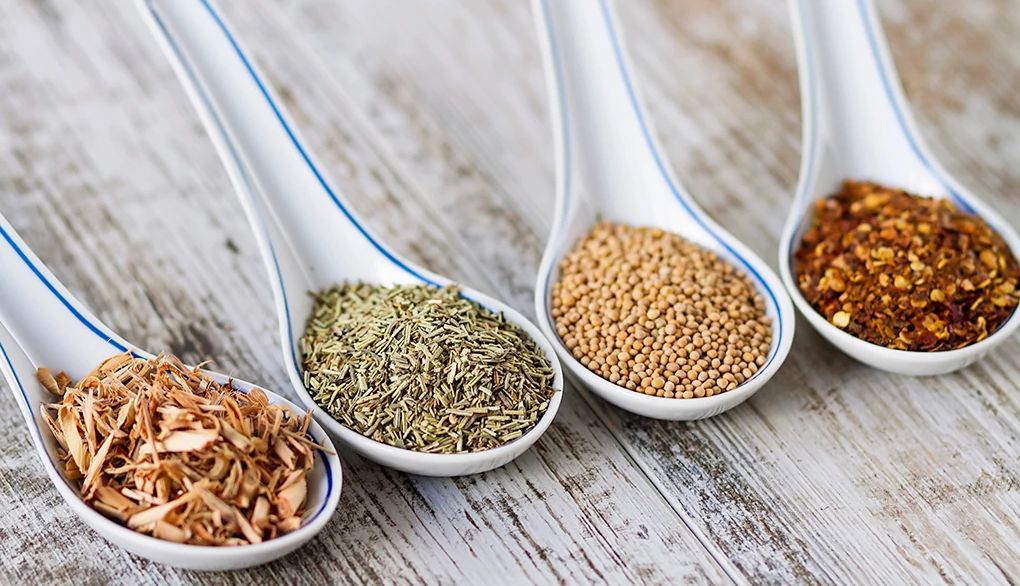 A healthy diet is crucial to optimal brain health A close-up view of spices and herbs in porcelain spoons over a wooden background