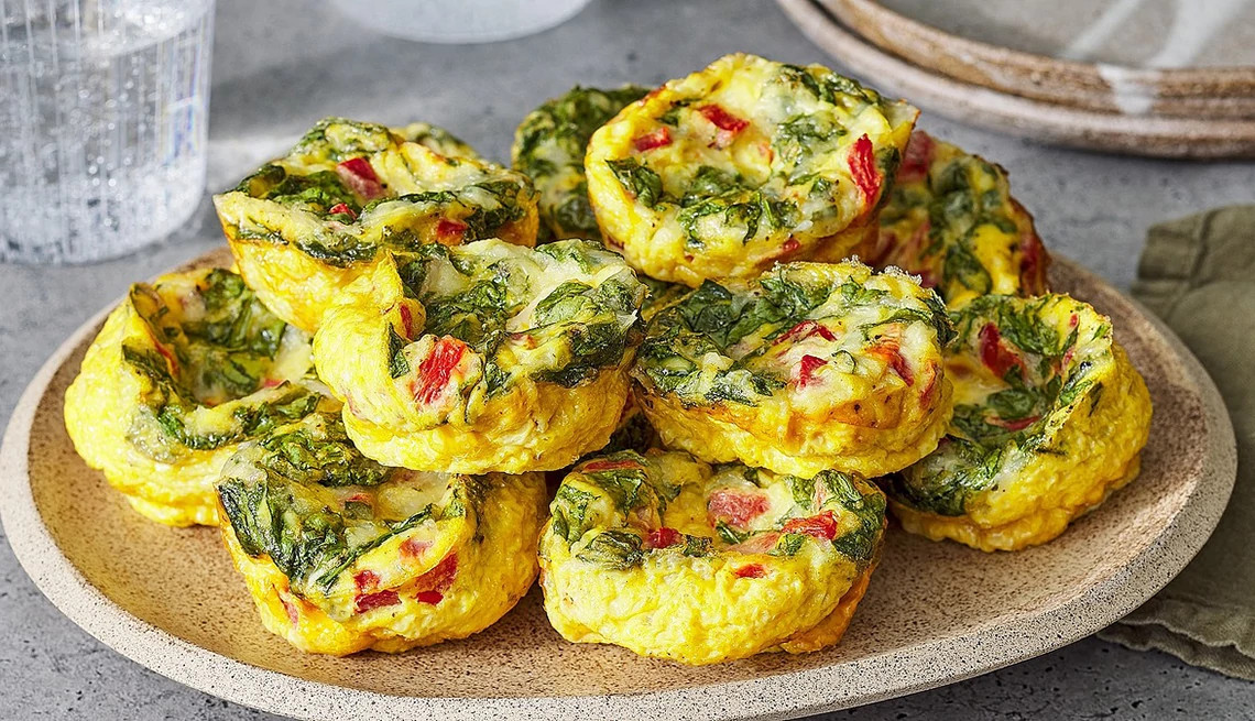 A close-up view of roasted red pepper and spinach egg bites on a plate