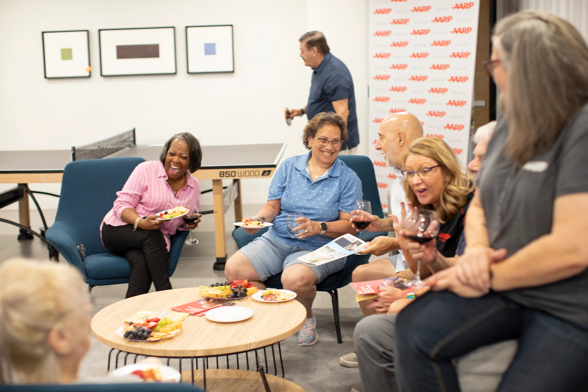 A group of woman sit in lounging chairs laughing and enjoying 
life.