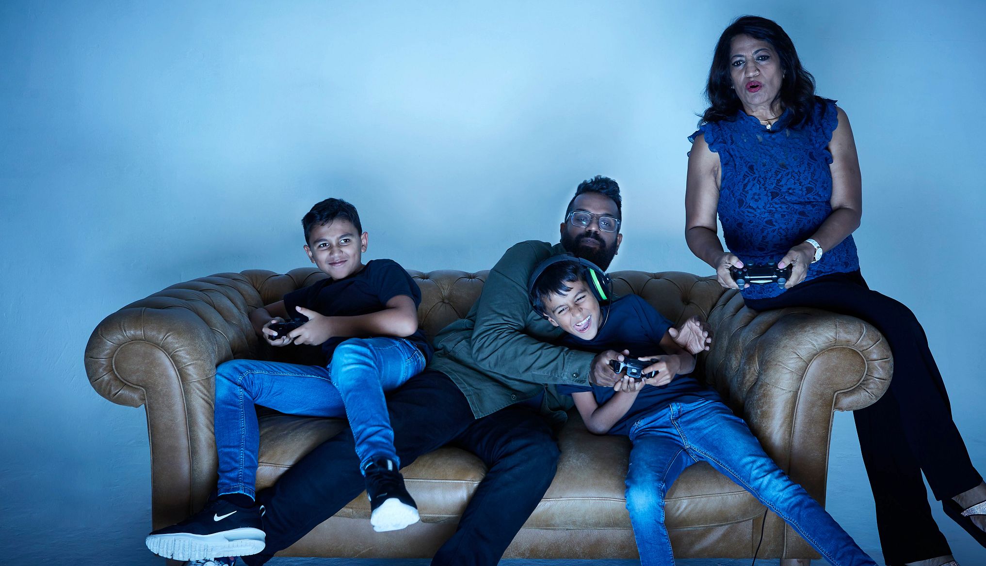 Fortnite Refund A family of four enjoys playing a video game from their couch in this photo