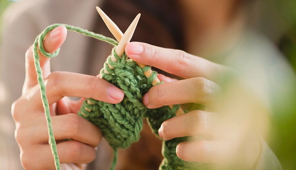 Crafting with yarn helps relieve stress A close-up view of a person knitting with needles and yarn