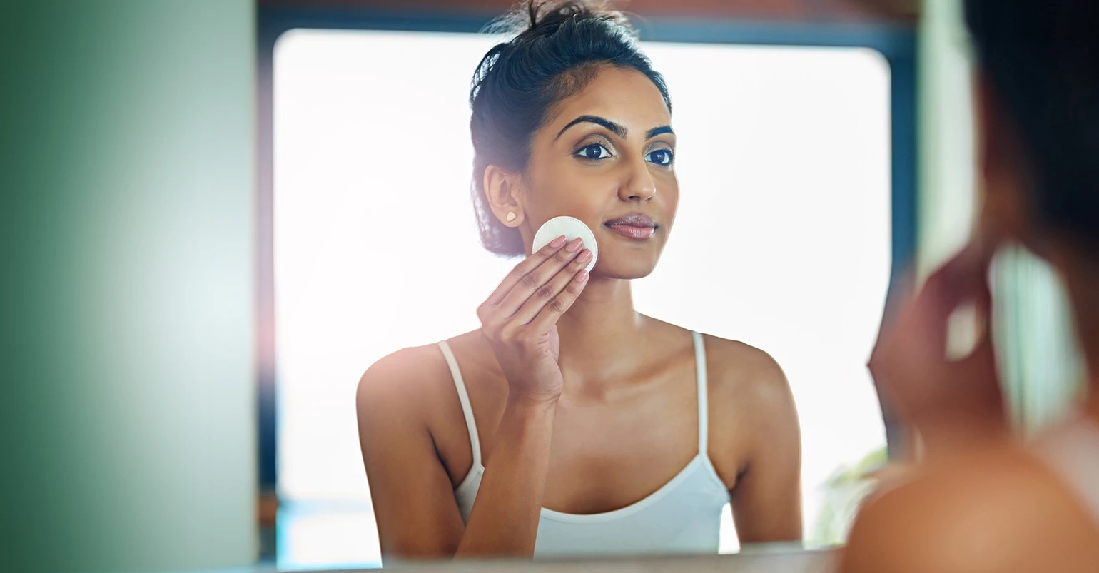  young woman cleaning her face with micellar water in the bathroom