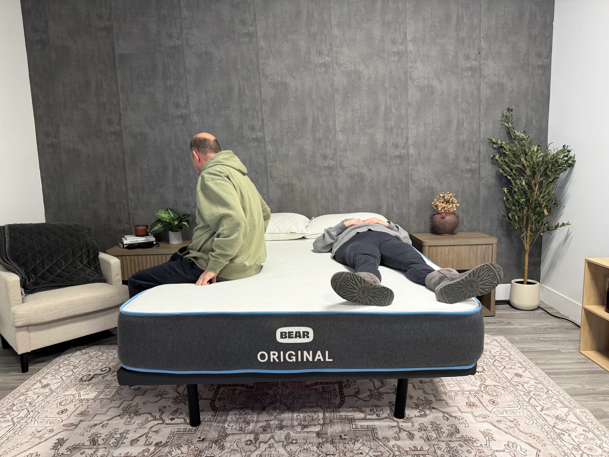 One man sitting and one woman lying on the Bear Original mattress