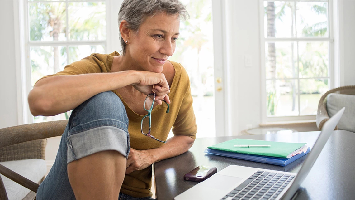 smiling woman looking at laptop