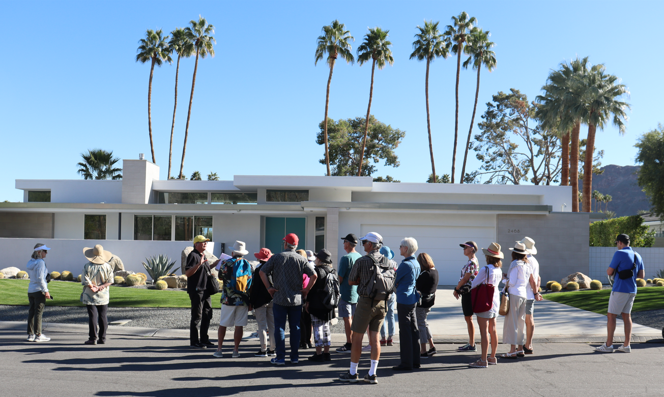 people standing outside looking at a home