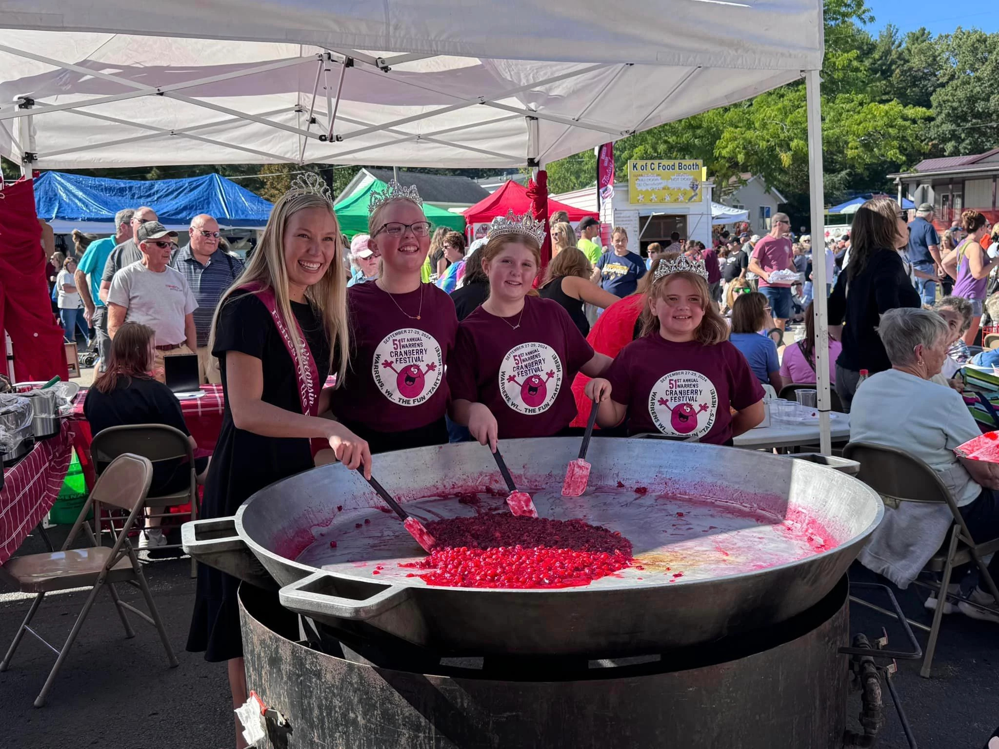 a woman and girls making cranberries jubilee at an event
