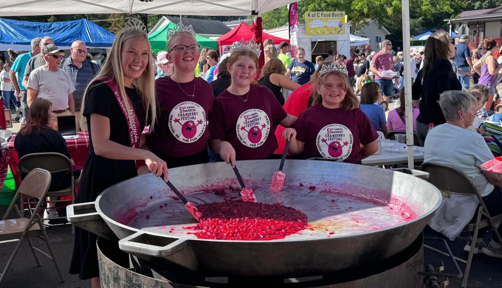 Colorful Fall Fests a woman and girls making cranberries jubilee at an event