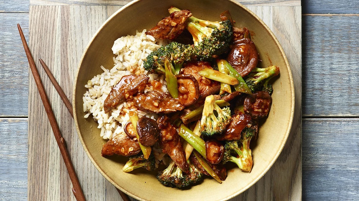 A close-up view of broccoli, mushroom and beef stir-fry in a plate