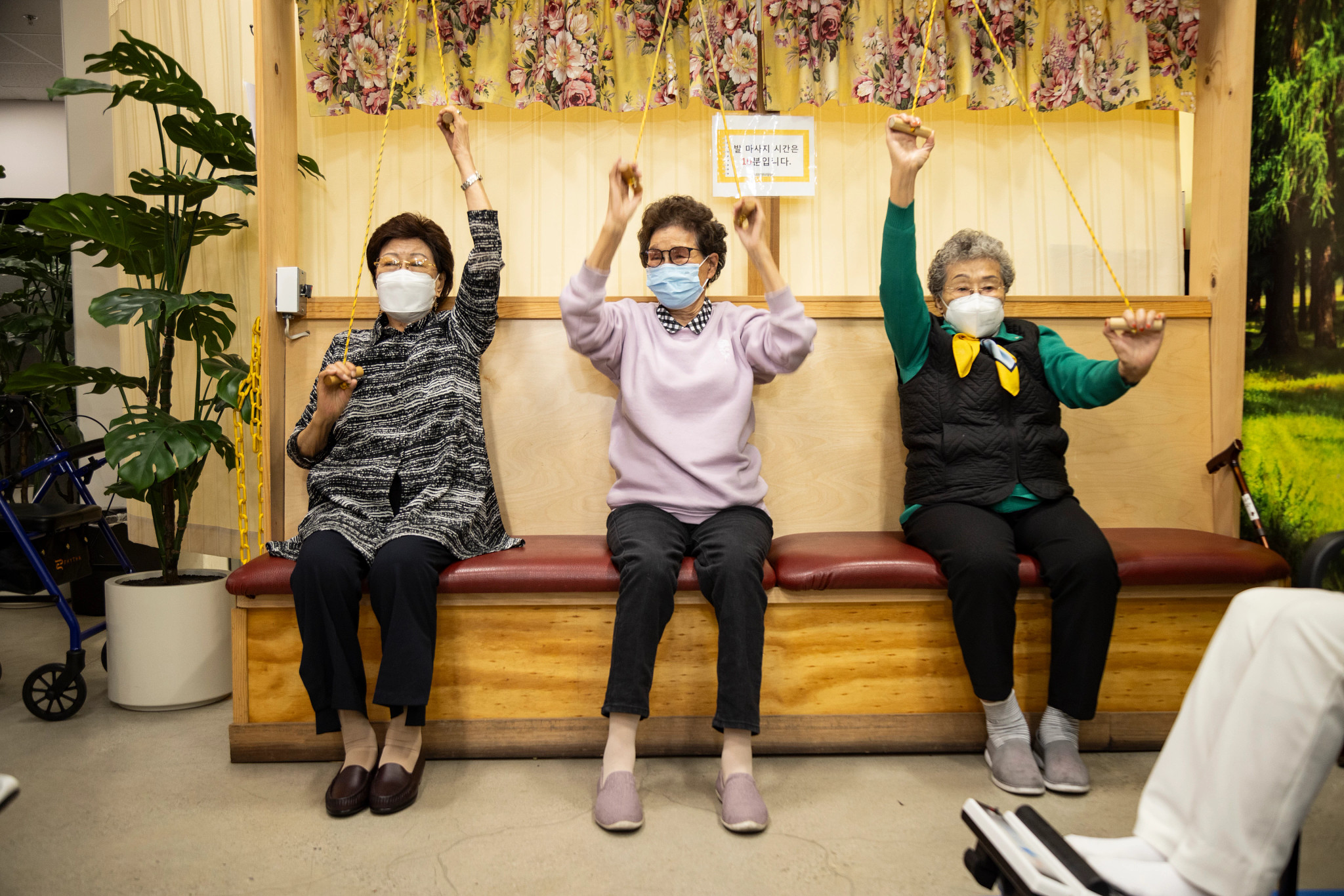 three women sitting down exercising