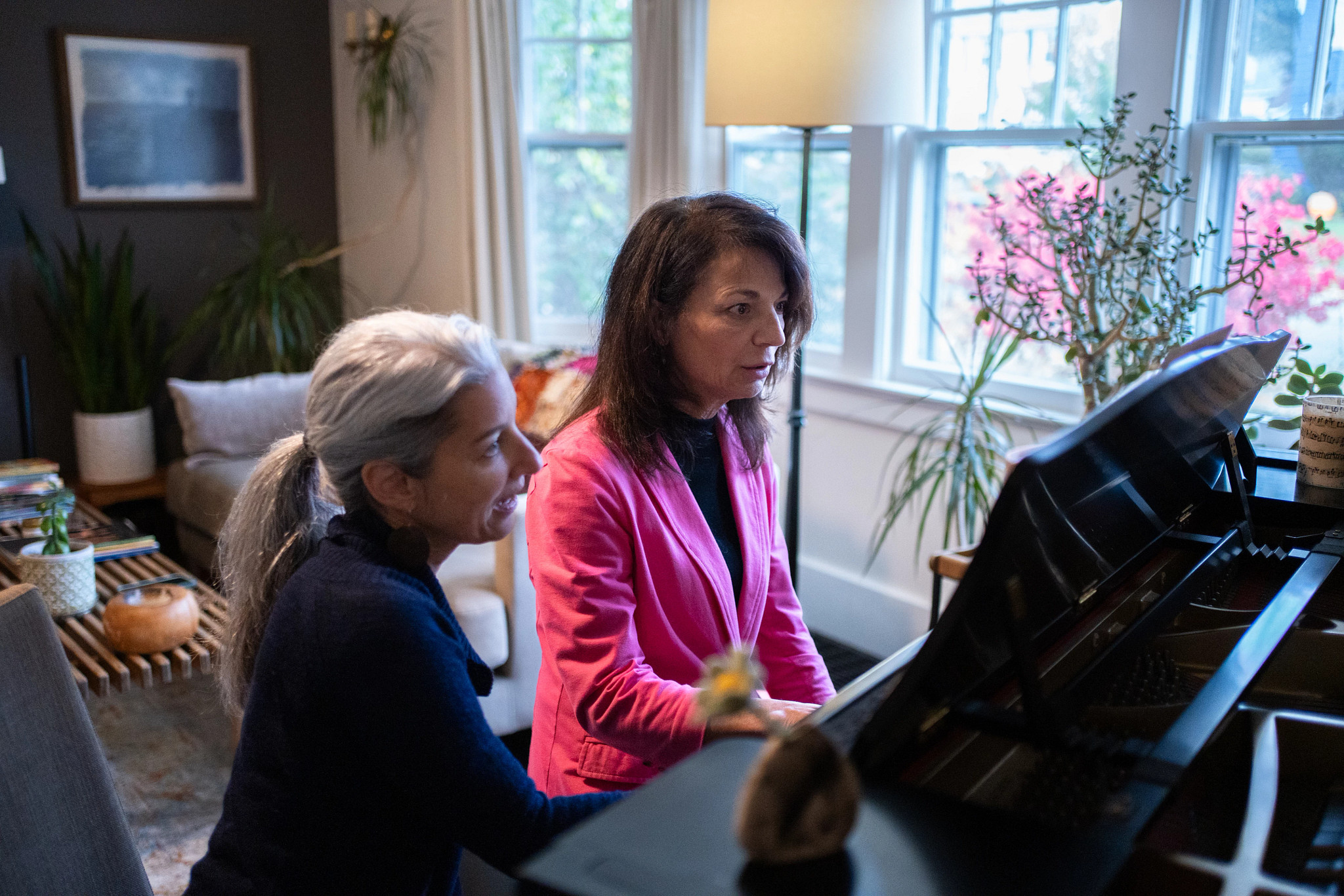 Flanigan, left, leads Pam Emigh-Murphy in a piano lesson.