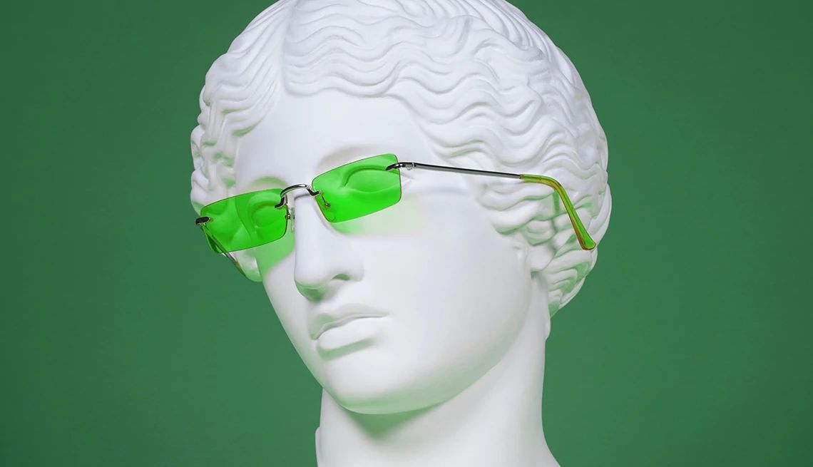 Green light therapy for pain relief White bust of a woman wearing green eyeglasses with a dark green background