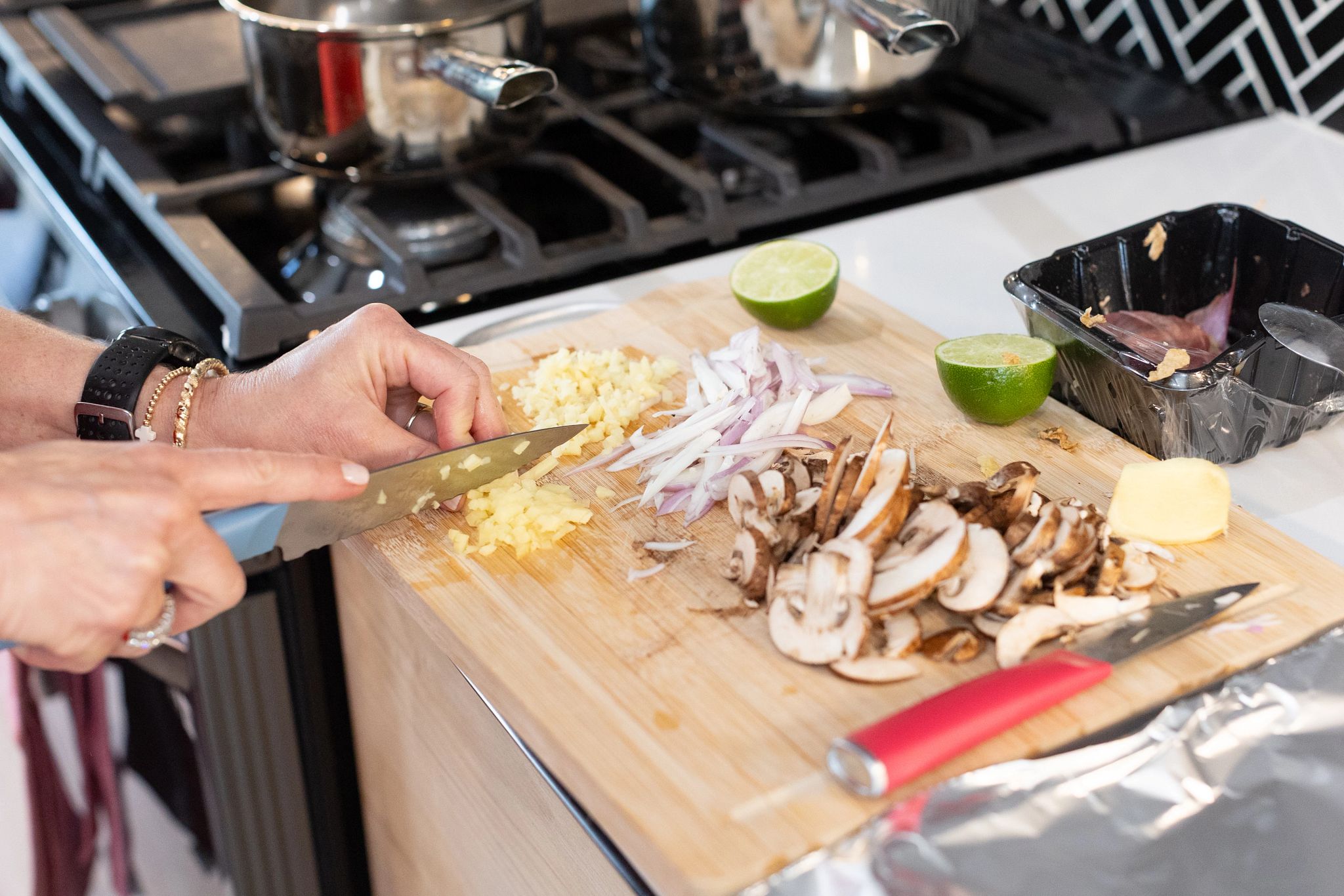 An older adult woman chopping up ingredients for her Purple Carrot meal kit.