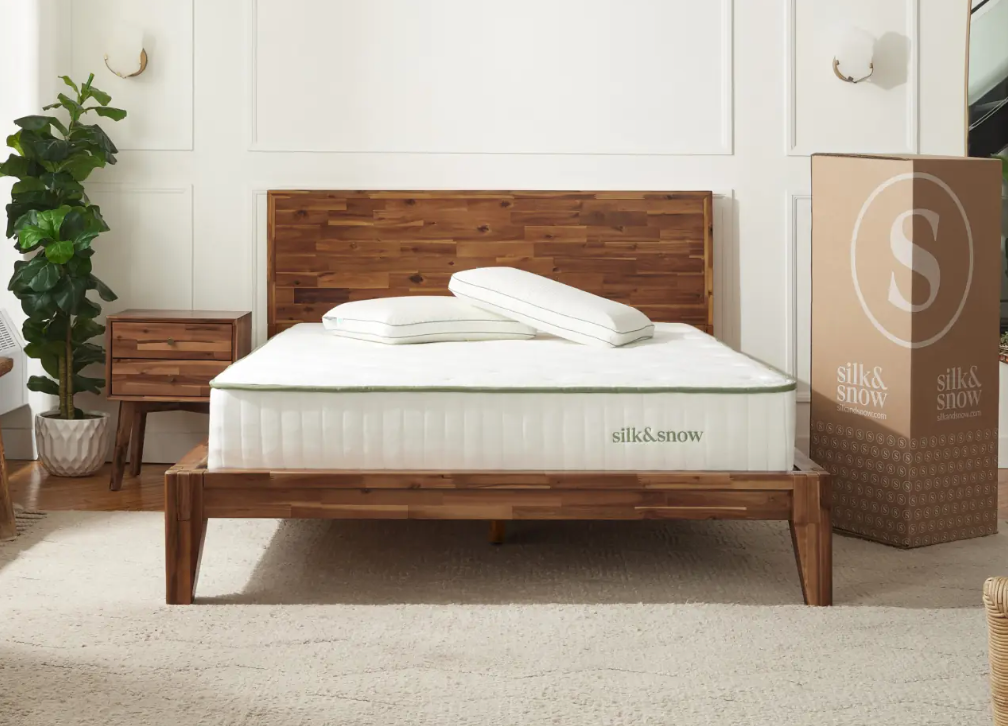 Silk & Snow Organic on a dark wooden bed frame in a light neutral room