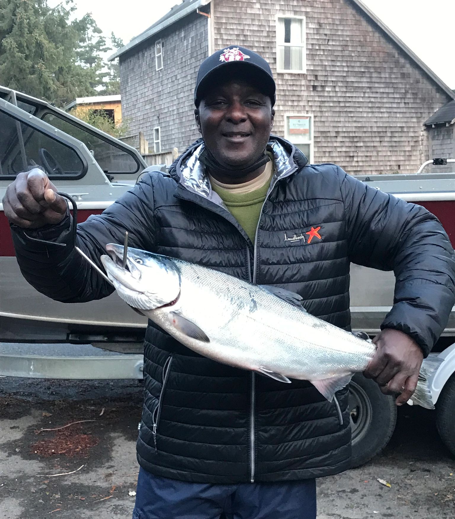 Retirementmoon a man poses while holding a large fish on a hook