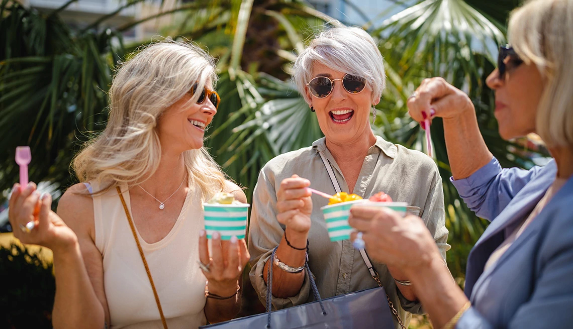 Group of women eating gelato with palm trees in the background